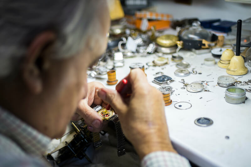 zegarmistrz podczas ręcznego wykańczania mechanizmu